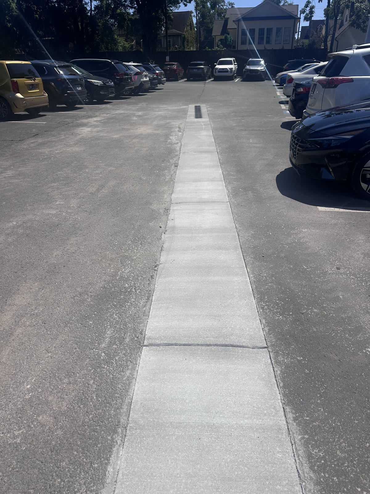 Completed concrete drainage channel running through a Nashville commercial parking lot
